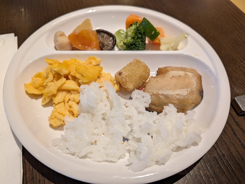 子供向けワンプレートに盛り付けられたスクランブルエッグとごはん、温野菜