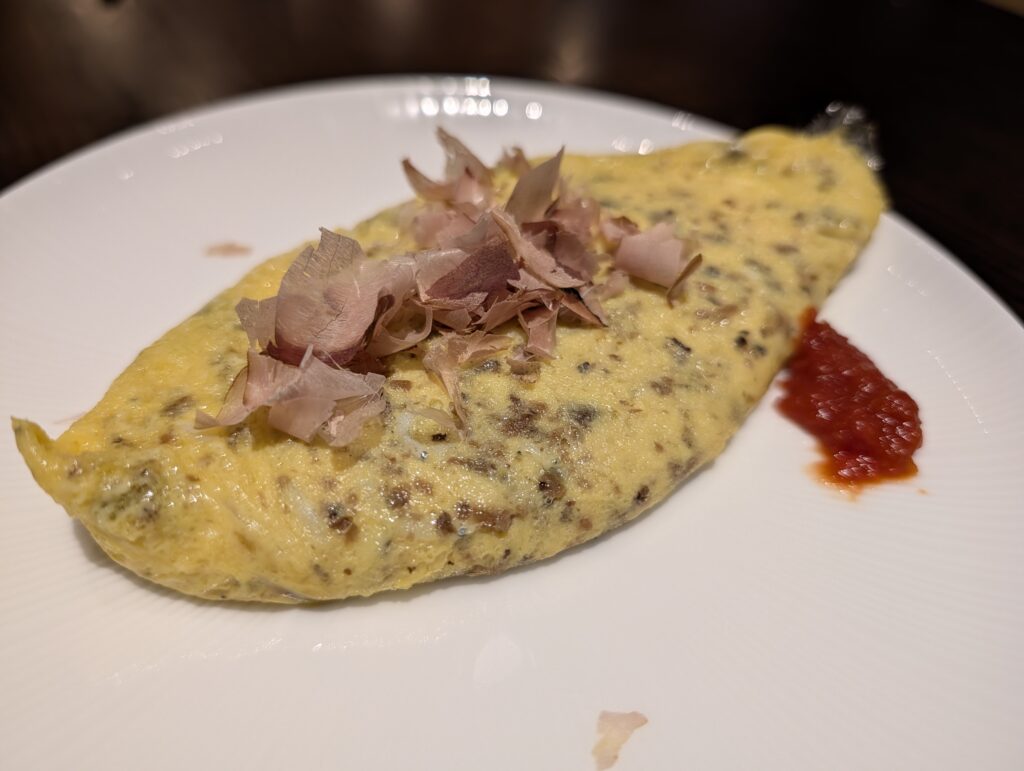 削り節と和風ソースが添えられた焼き立ての特製オムレツ