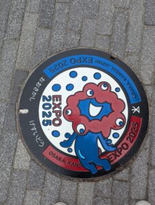 大阪市内に設置された大阪・関西万博公式キャラクター「ミャクミャク」のデザインマンホール蓋