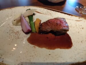 栃木県産牛のローストと温野菜に味わい深いソースが添えられたメインディッシュ