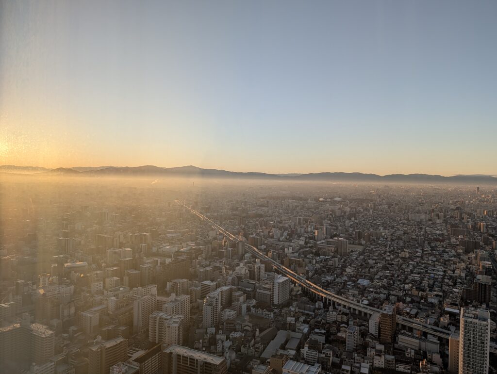 大阪マリオット都ホテルの高層階から見渡す早朝の街並みと遠くの山並み