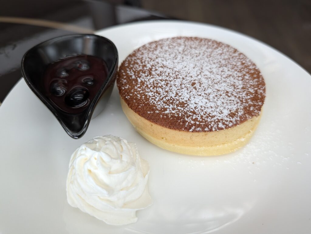 粉砂糖がふんわりとかかったパンケーキとブルーベリーソース・生クリーム