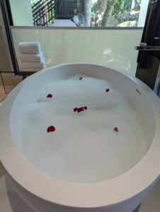 薔薇の花びらと泡が浮かべられた贅沢なバスタブのフラワーバス演出